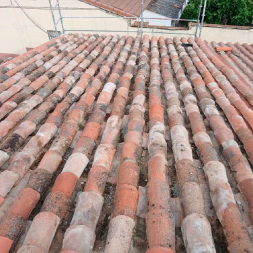 Vista de tejado de vivienda con tejas antiguas y nuevas