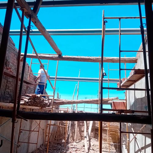 Obra en ejecución con andamios y trabajadores